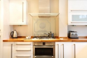 10713228-modern-kitchen-with-a-gas-hob-chimney-hood-wooden-worktops-and-stainless-steel-appliances