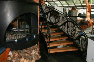 4739894-816952-wooden-staircase-with-wrought-iron-railings-and-a-fireplace-in-the-interior