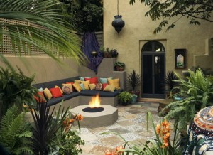 Concrete-Corner-Wall-Seating-with-Colorful-Cushions-and-Round-Fire-Pit-with-Concrete-Small-River-Stone-in-Mediterranean-Patio-Design-Ideas