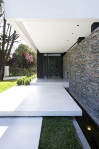 Carrara-House_11-Contemporary-White-Residence-by-Andres-Remy-Arquitectos-entrance-with-white-rustic-stone-and-stone-walls