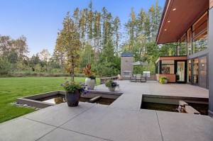 backyard-landscaping-equip-modern-house-design-with-dining-table-and-chairs-under-umbrella-as-well-as-koi-fish-pond-915x609