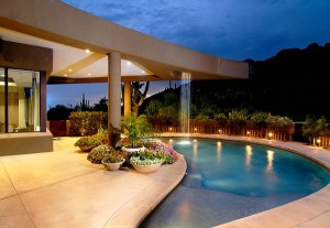 Lavish-Inground-Swimming-pool-Built-with-Chic-Curved-Design-with-Lush-Colorful-Flowers-and-Dim-Lighting