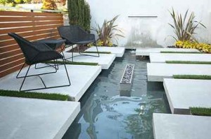 Modern-seating-area-with-a-water-feature-modern-black-chairs-and-black-coffee-table-wooden-fence-minimalist-exterior-design