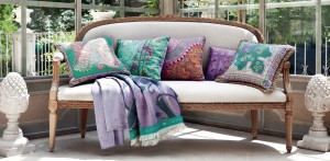 modern-outdoor-patio-furniture-with-elongated-chair-and-patterned-accents-pillows-also-purple-green-balnkets-and-carved-sculpture