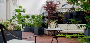 Luxury-Hotel-Burgundy-Paris-roof-terrace-garden-with-upholstered-furniture-and-coffe-tables-and-rich-vegetation-decoration