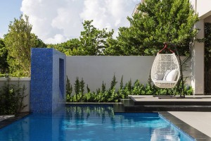 Garden-swing-with-modern-white-design-placed-near-a-luxurious-pool