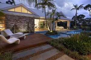 mesmerizing-modern-backyard-landscape-ideas-plus-wood-deck-and-unique-lounge-chair-as-well-as-small-island-in-pool-with-big-palm-tree-as-also-stone-walkway